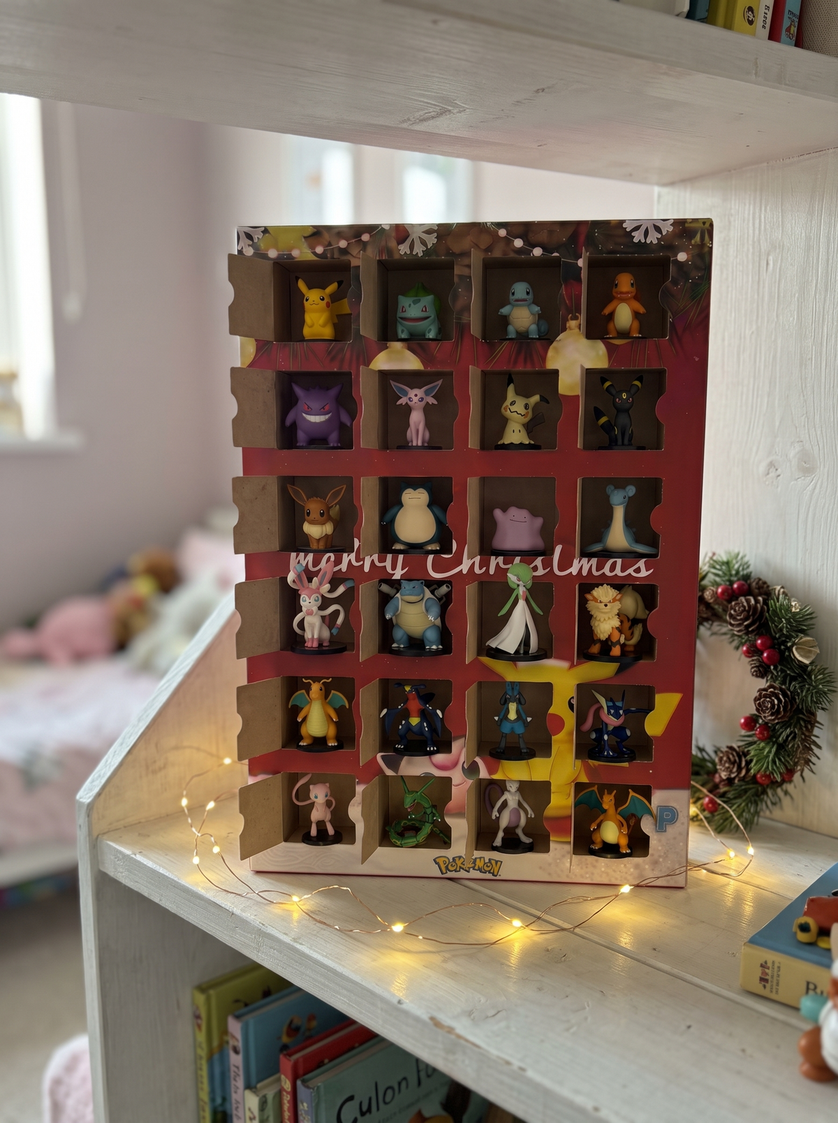Opened advent calendar with all 24 figures on a kid's bedroom shelf
